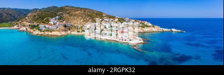 Un incantevole villaggio greco di pescatori di Armenistis in una tranquilla mattinata d'estate. Porto con spiaggia locale in acque cristalline a Ikaria, Grecia Foto Stock