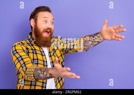 Foto di un ragazzo funky positivo felicissimo che indossa abiti eleganti che si abbracciano osservando lo spazio vuoto isolato su sfondo viola Foto Stock