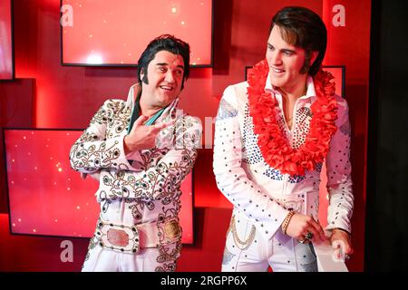 Berlino, Germania. 11 agosto 2023. L'interprete di Elvis Grahame Patrick (l) della serie "Stars in Concert" si trova accanto a una figura di Elvis appena restaurata nel museo delle cere di Madame Tussauds Berlin. Fino ad ora, la figura era raffigurata nell'uniforme dell'esercito degli Stati Uniti, mentre il cantante la indossava nel 1958 durante il suo servizio militare nella Germania Ovest. Dopo 15 anni al servizio del museo delle cere, Elvis ha ricevuto negli ultimi mesi un nuovo vestito e un nuovo taglio di capelli. Credito: Soeren Stache/dpa/Alamy Live News Foto Stock