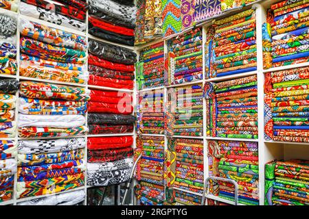 Tessuti e modelli africani e afro-caraibici venduti in un negozio a Brixton Village, popolare sala giochi al coperto, Brixton, South London, Inghilterra, Regno Unito Foto Stock
