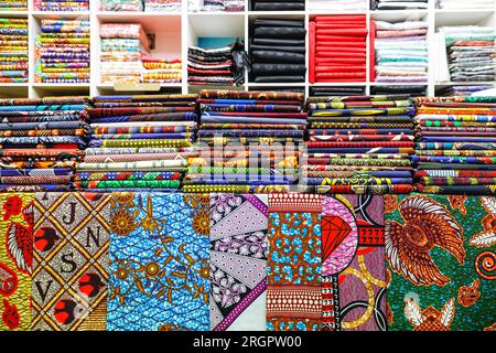 Tessuti e modelli africani e afro-caraibici venduti in un negozio a Brixton Village, popolare sala giochi al coperto, Brixton, South London, Inghilterra, Regno Unito Foto Stock