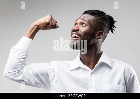 Ritratto emotivo di un uomo nero vincente, braccia verso il cielo. Non fortuna, ma il duro lavoro ha portato successo. Sorridere, festeggiare le buone notizie e migliorare la prospec Foto Stock