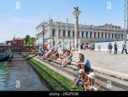 Venezia, Italia - maggio 30 2023: Folle di turisti che passeggiano sul vicolo acciottolato vicino al Canal grande a Venezia. Foto Stock