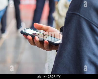 Mano dell'uomo che tiene lo smartphone. Foto Stock