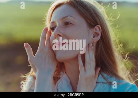 Giovane dolce donna bionda ritratto in campo estivo Foto Stock