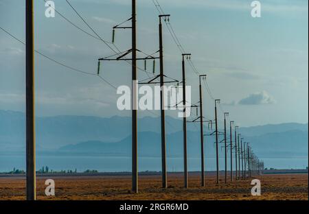 Linee elettriche in campo su montagne e laghi Foto Stock