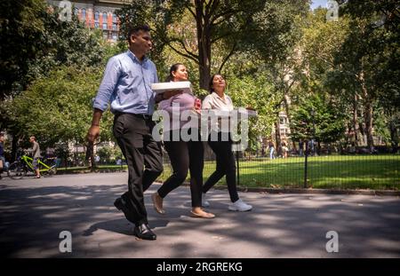 I lavoratori con i loro pranzi da asporto camminano attraverso il Madison Square Park a New York mercoledì 9 agosto 2023. (© Richard B. Levine) Foto Stock