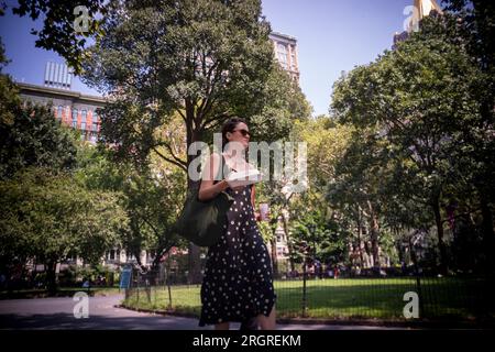 I lavoratori con i loro pranzi da asporto camminano attraverso il Madison Square Park a New York mercoledì 9 agosto 2023. (© Richard B. Levine) Foto Stock