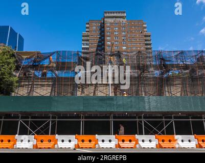 Edificio commerciale vuoto coperto da impalcature e un capannone per marciapiedi, che in precedenza ospitava un McDonald's, un supermercato Gristedes, un centro tennis e alcune piccole imprese, a Chelsea a New York martedì 8 agosto 2023. L'edificio, di proprietà della cooperativa Mutual ReDevelopment Housing, ha raggiunto la fine della sua vita ed è in procinto di scendere, per essere sostituito da alloggi. (© Richard B. Levine) Foto Stock