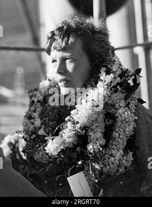 Honolulu, Hawaii: 27 dicembre 1934 Un primo piano del volantino femminile più importante del paese, Amelia Earhart Putnam, mentre arriva alla sua prima visita nel territorio delle Hawaii e viene accolta dai suoi ammiratori con leis floreali. Foto Stock