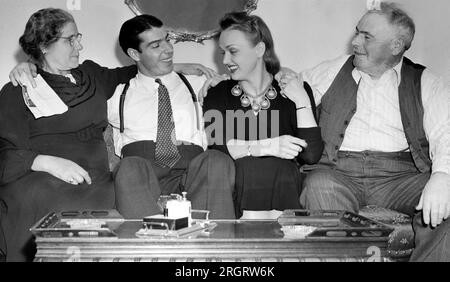 San Francisco, California: 1940 circa Joe DiMaggio siede su un divano con la moglie, l'attrice Dorothy Arnold, e i suoi genitori, Giuseppe e Rosalie DiMaggio. Foto Stock