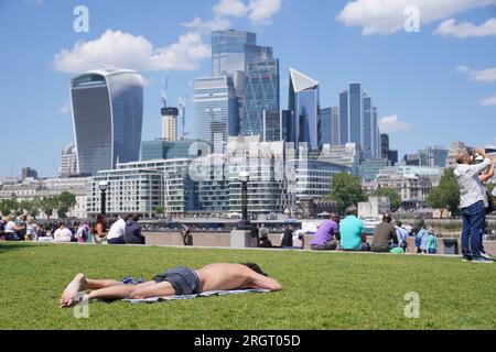 Foto datata 07/07/23 delle persone godono del clima caldo con una vista dello skyline della città di Londra dal Potters Fields Park di Londra. I mercati principali della città hanno registrato un calo di valore venerdì, in quanto la crescita economica del Regno Unito a giugno è stata migliore del previsto e il secondo trimestre del 2023 nel suo complesso ha alimentato la speculazione sui continui aumenti dei tassi di interesse da parte della Banca d'Inghilterra. Data di emissione: Venerdì 11 agosto 2023. Foto Stock