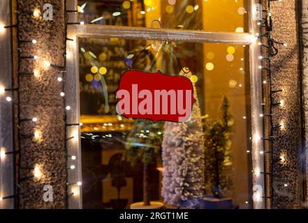 Cartello vuoto vuoto, cartello appeso alla finestra del caffè o della caffetteria, decorato per le vacanze di Natale, l'inverno e la vigilia di Capodanno. Foto Stock