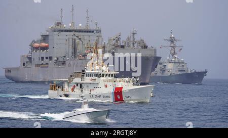 Una nave di superficie senza equipaggio L3 Harris Arabian Fox MAST-13, USCGC Charles Moulthrope (WPC 1141), nave da carico secco e munizioni USNS Amelia Earhart (T-AKE 6) e cacciatorpediniere missilistico guidato USS Thomas Hudner (DDG 116) navigano insieme durante un transito attraverso lo stretto di Hormuz, il 6 agosto 2023. Foto tramite U.S. Navy/UPI Credit: UPI/Alamy Live News Foto Stock