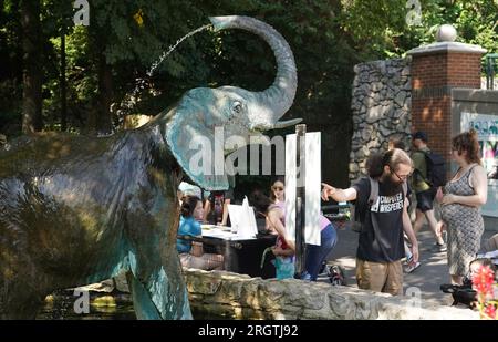 St Louis, Stati Uniti. 11 agosto 2023. I visitatori dello zoo di Saint Louis si fermano per osservare la statua dell'elefante a St Louis venerdì 11 agosto 2023. Lo zoo sponsorizzò l'evento "Toss the Tusk", che incoraggia il pubblico a cedere i ciondoli fatti da parti di animali in pericolo il giorno prima della giornata mondiale degli elefanti. Foto di Bill Greenblatt/UPI credito: UPI/Alamy Live News Foto Stock