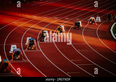 B. BYSTRICA, SLOVACCHIA, 20 LUGLIO 2023: Uomini posizionati all'inizio di 200 m Sprint, bagnati da un'illuminazione al tramonto delicata, al Track and Field Championshi Foto Stock