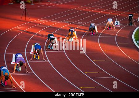 B. BYSTRICA, SLOVACCHIA, 20 LUGLIO 2023: Maschio Sprinters assemblato alla linea di partenza di 200m Race nel suggestivo Glow of Sunset for Worlds a Budapest Foto Stock