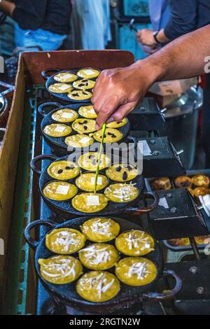 Queste deliziose prelibatezze sono una fusione di sapori e consistenze ricche, con uno strato esterno croccante che abbraccia un centro morbido e appagante. Un simbolo di lei locale Foto Stock