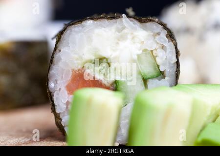 A base di riso alla trota e sushi verdure, riso asiatico e frutti di mare sul tavolo durante i pasti Foto Stock