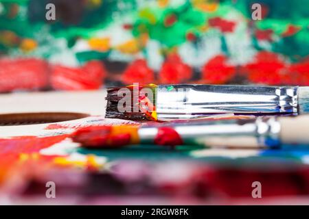 olio e altre vernici con pennelli per la creatività, il processo creativo di disegno mescolando diversi colori di vernici con pennelli artistici, pennelli artistici a. Foto Stock