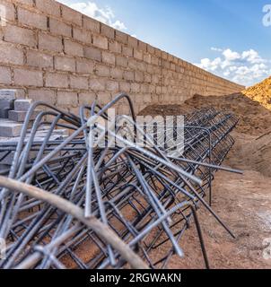 rete metallica utilizzata nella costruzione per rinforzare le montagne di cemento di terreno fresco scavato sullo sfondo Foto Stock