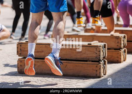 Persone che si allenano saltando su ostacoli di legno, fitness, palestra. Foto Stock