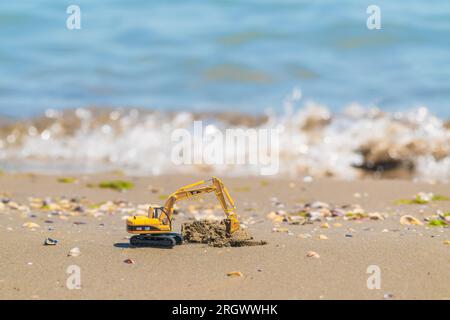 Escavatore modello Caterpillar su spiagge sabbiose Foto Stock