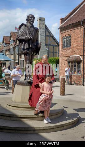 I turisti cinesi del Regno Unito che si mettono in posa per una fotografia con la statua di William Shakespeare a Stratford Upon Avon, Inghilterra Foto Stock