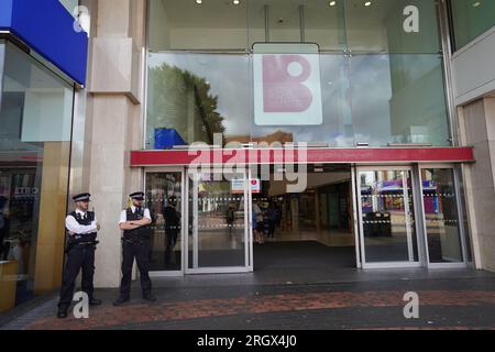 Gli agenti di polizia si trovano all'esterno del Broadway Shopping Centre a Bexleyheath, a sud-est di Londra, dove le aziende sono state avvertite di prepararsi per "bande di giovani" per effettuare un presunto raid ispirato a TikTok. Data foto: Sabato 12 agosto 2023. Foto Stock