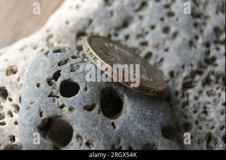 Bordo della moneta del Regno Unito da 2 sterline. Moneta sulle pietre. Foto Stock