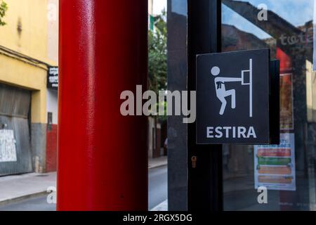 Primo piano di un simbolo di allungare la porta per aprirla, scritto in spagnolo. Manacor, isola di Maiorca, Spagna Foto Stock