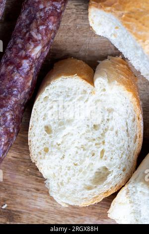 i pezzi di salsiccia affettati di carne sono sdraiati su un tagliere, la carne di maiale con la pancetta è secca e appassita, la carne è pronta per mangiare Foto Stock