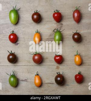 una varietà di pomodori freschi multicolori su un tavolo di legno Foto Stock