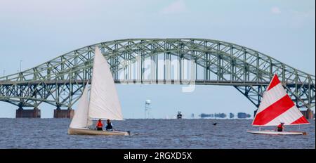 Piccole barche a vela personali che si godono una giornata nella Great South Bay con il ponte e Fite Island sullo sfondo. Foto Stock