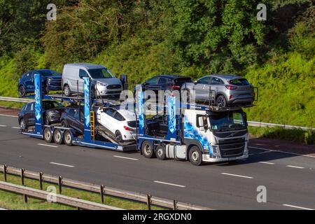 Le nuove Ford Puma Cars saranno consegnate su CT27 167 8 rimorchio per autotrasportatore e 2016 Volvo FH Diesel Truck da 12777 cc; viaggia a velocità sostenuta sull'autostrada M6 a Greater Manchester, Regno Unito Foto Stock