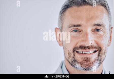 Medico uomo, colpo alla testa e spazio con sorriso in ritratto, mockup o promozione per il dipendente dell'ospedale. Professionista sanitario, esperto e leader maturo Foto Stock