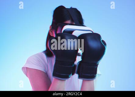 Realtà virtuale, fitness e pugilato femminile negli eSport, videogiochi e lotta in studio su sfondo blu con la tecnologia dei visore. 3d, esercizio fisico e realtà virtuale Foto Stock