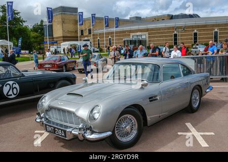 British Motor Museum Gaydon, Warwickshire, Regno Unito. Sabato 12 agosto 2023. L'Aston Martin Heritage Trust celebra il suo 25° compleanno. La folla si diverte a vedere il modello di continuazione della Aston Martin DB5 Goldfinger. L'auto raffigurata è il prototipo del modello continuativo che era limitato ad una produzione di 25, ad un costo di 3,5 milioni di sterline ciascuno. L’evento ha celebrato questo insieme a tutte le cose “Aston”. Altre celebrazioni, tra cui - 60 anni della DB5 - 20 anni della DB9 - 75 anni della linea di sangue DB - 110 anni di Aston Martin Lagonda. Crediti: Ian Tennant / Alamy Live News. Foto Stock