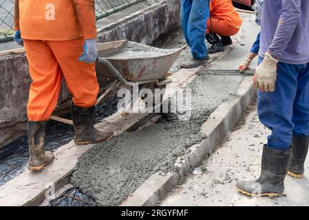 Salvador, Bahia, Brasile - 11 agosto 2023: Si vedono i lavoratori edili che riparano un marciapiede sull'Avenida Tancredo Neves a Salvador, Bahia, Foto Stock