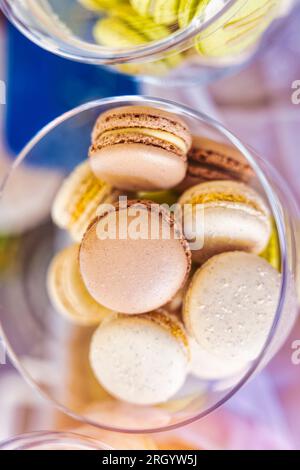 mercatino delle pulci, biscotti di maccheroni sul tavolo in vasetti di vetro, vari colori, ripieno di crema di cocco, vista dall'alto Foto Stock