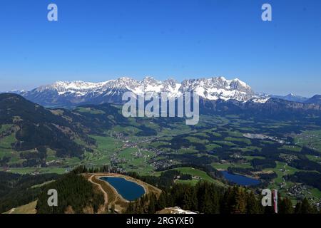 Il maestoso Wilder Kaiser e la splendida valle di Kitzbuehel, vista dalla cima della montagna alpina Hahnenkamm in primavera Foto Stock