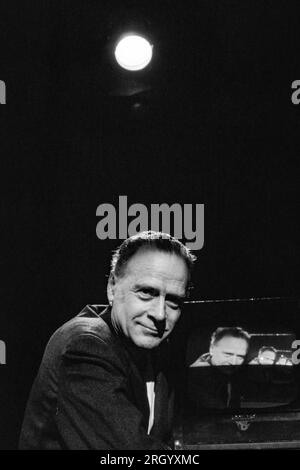 Marshall McLuhan - con set televisivo - è stato un filosofo canadese il cui lavoro è tra le pietre miliari dello studio della teoria dei media. Ha studiato presso l'Università di Manitoba e l'Università di Cambridge. Iniziò la sua carriera di insegnante di inglese in diverse università negli Stati Uniti e in Canada prima di trasferirsi all'Università di Toronto nel 1946, dove rimase per il resto della sua vita. McLuhan ha coniato l'espressione "il mezzo è il messaggio" nel primo capitolo della sua comprensione dei media. Fotografia di Bernard Gotfryd Foto Stock