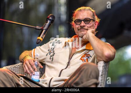 Cottbus, Germania. 12 agosto 2023. L'attore Götz otto siede su un palco al Festival di Elbenwald per un episodio dal vivo della commedia radiofonica 'Kohlrabenschwarz'. L'Elbenwald Festival è un raduno di tre giorni per persone di tutte le età che amano film, fantasia, giochi, concerti e qualsiasi combinazione di quanto sopra. Gli organizzatori si aspettano circa 15.000 visitatori. Crediti: Frank Hammerschmidt/dpa/Alamy Live News Foto Stock