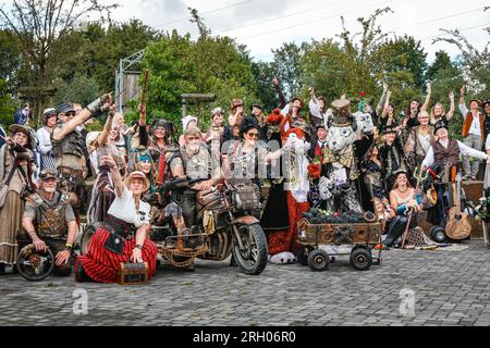 Henrichenburg, Waltrop, Germania. 12 agosto 2023. Le unità obbligatorie di foto di gruppo molti dei partecipanti e gruppi di oggi. Gli appassionati di steampunk, i gruppi in costumi e i visitatori, molti in abiti retrò-futuristici o di ispirazione vittoriana, si divertono nonostante le forti docce a pioggia del primo giorno del weekend del Festival del Giubileo di Steampunk presso lo storico skilift di Henrichenburg, un monumento architettonico e sito del patrimonio industriale. Crediti: Imageplotter/Alamy Live News Foto Stock