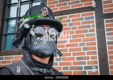 Henrichenburg, Waltrop, Germania. 12 agosto 2023. Darksteam il Dottore Pest posa. Gli appassionati di steampunk, i gruppi in costumi e i visitatori, molti in abiti retrò-futuristici o di ispirazione vittoriana, si divertono nonostante le forti docce a pioggia del primo giorno del weekend del Festival del Giubileo di Steampunk presso lo storico skilift di Henrichenburg, un monumento architettonico e sito del patrimonio industriale. Crediti: Imageplotter/Alamy Live News Foto Stock