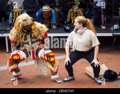 Lion People Dancing with member of the Public, (Zimba Lion Masquerade) at, Carnival of the World, Broad Street, Reading, Berkshire, Inghilterra, REGNO UNITO, REGNO UNITO. Foto Stock