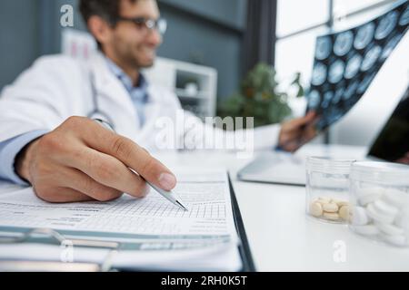 il medico prende appunti o ricette con penna a matita e carta per l'infermiere del paziente da vicino. ospedale medico Foto Stock