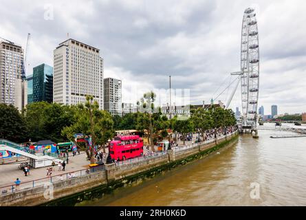 Vista a sud (a monte) lungo la Queen's Walk verso il London Eye sulla South Bank of the Thames Embankment, Londra SE1 Foto Stock