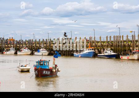 Un peschereccio e altre barche ormeggiavano con la bassa marea sul fiume Rother a Rye Harbour, un piccolo villaggio vicino alla città di Rye vicino alla costa nell'East Sussex Foto Stock