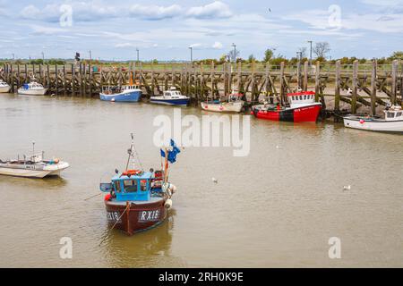 Un peschereccio e altre barche ormeggiavano con la bassa marea sul fiume Rother a Rye Harbour, un piccolo villaggio vicino alla città di Rye vicino alla costa nell'East Sussex Foto Stock